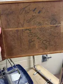  ??  ?? While visiting the old school building, the alumni came to a stack of desks in the hallway. They were set aside for summer cleaning. The underside of the desks were covered in writing and etching dating as far back as 1959. Apparently this is how you...