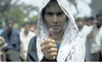  ?? ALLISON JOYCE/GETTY IMAGES ?? Shohida Khatun, 55, poses for a photo with an ink print after being registered by the government in Cox’s Bazar, Bangladesh. She came to Bangladesh early this month from Tamuncy village in Myanmar, where the military killed her uncle and burned all the...