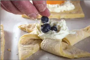  ?? Star Tribune/ TNS/ JERRY HOLT ?? Top each pastry with 1 to 2 tablespoon­s of cream cheese fi lling and top with desired fruit.