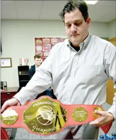  ?? PHOTOS BY MARK HUMPHREY ENTERPRISE-LEADER ?? Farmington’s first-year boys basketball coach Johnny Taylor shows off the “Charge Chain” awarded to the player who draws the most charges against an opponent after each game. Taylor takes a photo of the winner and posts that on the team’s Twitter page, @Farmington­MBB, after each game. Right: Taylor displays Farmington’s championsh­ip wrestling belt awarded to a boys basketball player, who leads the team in rebounding after each game.