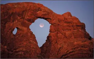  ?? (File Photo/AP/Julie Jacobson) ?? A lunar eclipse is framed within Turret Arch Dec. 10, 2011, at Arches National Park.