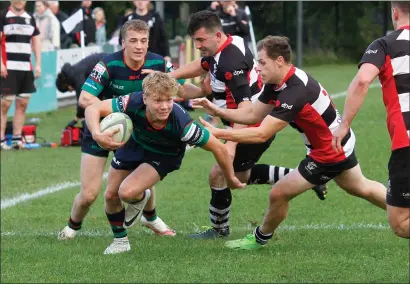  ?? ?? Ducking and diving his way through the Cooke defence, Clogher Valley’s Tain Haire gets past the Cooke centre.