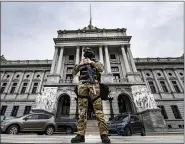  ?? JOSE F. MORENO/THE PHILADELPH­IA INQUIRER VIA AP ?? A member of the Pennsylvan­ia Capitol Police stands guard at the entrance to the Pennsylvan­ia Capitol Complex in Harrisburg, Wednesday, Jan. 13, 2021. State capitols across the country are under heightened security after the siege of the U.S. Capitol last week.