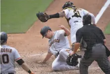  ?? Kelvin Kuo / Associated Press ?? Alex Dickerson slides into home ahead of the tag by San Diego catcher Luis Campusano for the goahead score in the 10th.