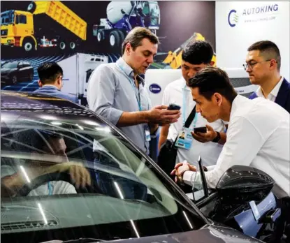  ?? LIU DAWEI / XINHUA ?? Prospectiv­e buyers inquire about new energy vehicles at a booth at the 133rd Canton Fair in Guangzhou, Guangdong province, on April 15. The fair, which runs through May 5, will see buyers from over 220 countries and regions, including the United States, Europe and emerging markets along the Belt and Road.