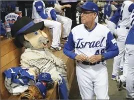  ?? Ap pHoto ?? Israel’s third base coach Pat Doyle passes by his team mascot, The Mensch on the Bench, during a first-round game of the World Baseball Classic in Seoul, South Korea.