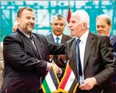  ?? DESOUKI/AFP KHALED ?? Fatah’s Azzam al-Ahmad (right) and Saleh al-Aruri of Hamas shake hands after signing a reconcilia­tion deal in Cairo on October 12.