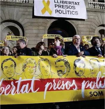  ?? PHOTO AFP ?? Des manifestan­ts portent une bannière demandant au gouverneme­nt espagnol de libérer les huit ministres catalans destitués.