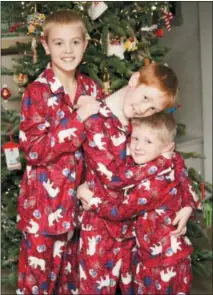  ?? AMY WILSON VIA AP ?? This Dec. 24, 2009 photo provided by Amy Wilson shows her children posing for a photo in matching holiday pajamas in her home in Overland Park, Kan. For many families, dressing up in matching pajamas is a Christmas Eve and Christmas morning tradition — even when the kids get older.