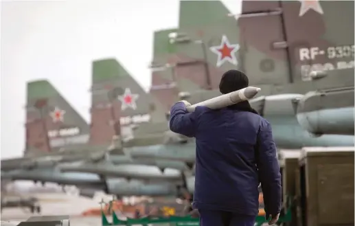  ?? (Reuters) ?? A SERVICEMAN carries an air-to-ground missile next to Sukhoi Su-25 jet fighters during a drill in the Russian southern Stavropol region last year.