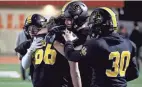  ?? SHANE FLANIGAN/THISWEEK ?? Upper Arlington’s Henry Rappolt, center, Jake Badgeley (66), Alex Milton (30) and Austin Stutz console each other following a 16-10 loss to St. Edward Friday.