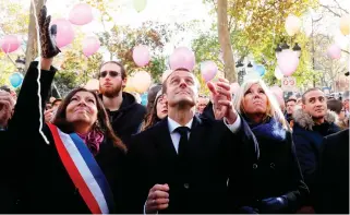  ??  ?? French President Emmanuel Macron, his wife Brigitte Macron (right), Paris Mayor Anne Hidalgo release balloons at Paris 11th district town hall on Monday, during a ceremony held for the victims of the Paris attacks. (AFP)