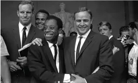  ?? Photograph: AP ?? ‘Baldwin discovered the cinema before he discovered books’ … the writer with Marlon Brando (centre) at the Lincoln Memorial in 1963, with Charlton Heston (left) and Harry Belafonte (behind).