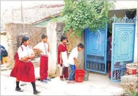  ?? PARWAZ KHAN/HT ?? Government school students collect water offered by residents in Ranchi’s Pathalkudw­a.