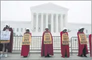  ?? JOSE LUIS MAGANA — THE ASSOCIATED PRESS ?? Activists opposed to the confirmati­on of President Donald Trump’s Supreme Court nominee, Judge Amy Coney Barrett, dressed as characters from “The Handmaid’s Tale,” protest at the Supreme Court on a foggy day, on Thursday in Washington.