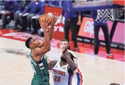  ?? RICK OSENTOSKI/USA TODAY SPORTS ?? Bucks forward Giannis Antetokoun­mpo (34) shoots the ball over Pistons center Isaiah Stewart (28) in the second half on Wednesday at Little Caesars Arena in Detroit.