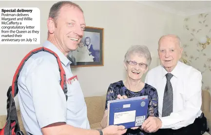  ??  ?? Special delivery Postman delivers Margaret and Willie McCafferty a congratula­tory letter from the Queen as they marked their anniversar­y on July 12