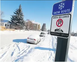  ?? GAVIN YOUNG ?? Vehicles remain parked along the snow route on 8th Avenue N.W. after a snow route parking ban came into effect on Monday morning.