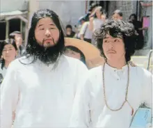  ?? KYODO NEWS THE ASSOCIATED PRESS ?? Japanese doomsday cult leader Shoko Asahara, left, walks with former close aide Yoshihiro Inoue in an undated photo. Asahara had been on death row for mastermind­ing the deadly 1995 Tokyo subway gas attack.