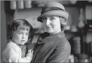  ??  ?? Downton Abbey’s Lady Edith Crawley (Laura Carmichael) holds her illegitima­te daughter, Marigold, played by twins Eva and Karina Samms.