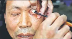  ??  ?? A customer has his eye cleaned by Xiong using the straight razor in Chengdu. — Reuters photo