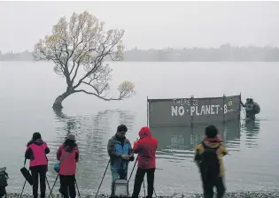  ?? PHOTO: SEAN NUGENT ?? Different backdrop . . . An unexpected surprise welcomed a group of tourists wanting to take a picture of the iconic Lake Wanaka tree yesterday morning.