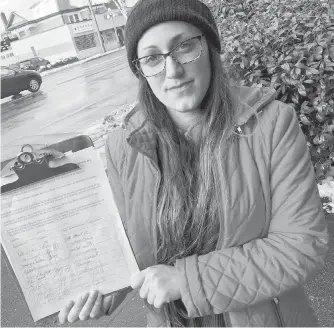  ??  ?? Rachel White holds a petition for legislatio­n to allow people with disabiliti­es to have emotional support animals in rental buildings.