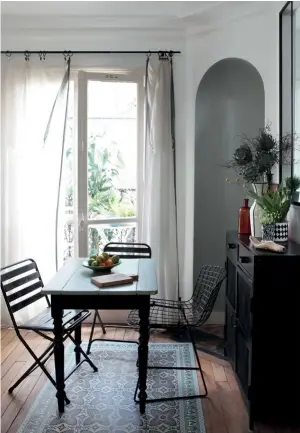  ??  ?? LumièrE Autour de la table à manger repeinte en noir et vert amande, chaise (Knoll) et tapis en vinyle (Beija Flor) imitant des carreaux de ciment.