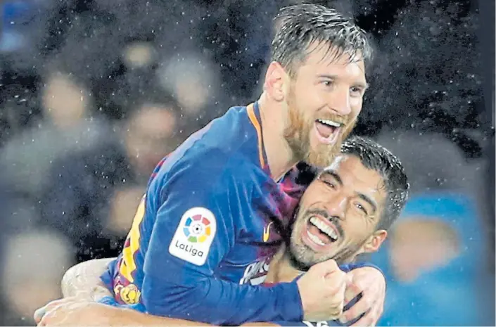  ?? EFE ?? Amigos en la red. Messi y Suárez, la mayor sociedad del Río de la Plata, festejan bajo la lluvia. El Barça llevaba más de una década sin victorias como visitante de la Real Sociedad.