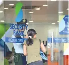  ??  ?? A CUSTOMER enters a branch of Security Bank in Manila.