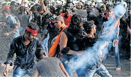  ?? | AFP ?? A DEMONSTRAT­OR throws back a tear gas canister fired by the police to disperse university students protesting to demand the resignatio­n of Sri Lanka’s President Gotabaya Rajapaksa over the country’s crippling economic crisis, in Colombo, yesterday.