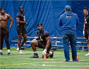  ?? Lori Van Buren/times Union ?? Defensive lineman Amitral Simon Jr., center, listens as a New York Giants scout explains the next drill at Ualbany football’s Pro Day at Afrim’s Sports Park.