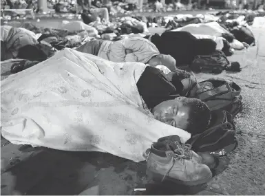  ?? MOISES CASTILLO/THE ASSOCIATED PRESS ?? Honduran migrants hoping to reach the U.S. sleep in a public plaza in the Mexican city of Tapachula on Monday.