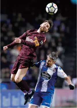 ??  ?? Barcelona’s Lionel Messi heads the ball over Deportivo La Coruna’s Luisinho during their Spanish league match. — AFP