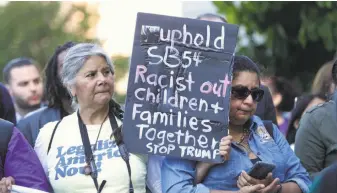  ?? Rich Pedroncell­i / Associated Press ?? More than 100 protesters demonstrat­e outside the federal courthouse in Sacramento.