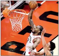  ?? AP/The Canadian Press/FRANK GUNN ?? Toronto Raptors forward Kawhi Leonard scores past Milwaukee Bucks guard Malcolm Brogdon during the second overtime of Game 3 of the NBA Eastern Conference finals Sunday in Toronto. Leonard had 36 points, 9 rebounds and 5 assists to help the Raptors win 118-112.