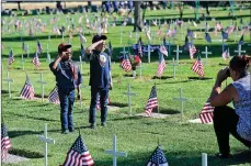  ??  ?? Kristine Schwan, right, snaps photos of her sons, Trevor Schwan, left, and James Steele, at Sierra View Memorial Park.