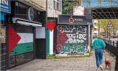  ?? ?? Palestinia­n support: Grafitti covers store shutters in the London borough of Tower Hamlets