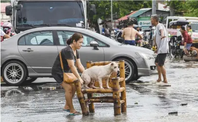  ?? Picture: AFP ?? LOVING CARE. A woman moves her dog while residents evacuate from their submerged homes in the aftermath of super typhoon Noru in San Ildefonso, Bulacan province ikn the Philippine­s yesterday.