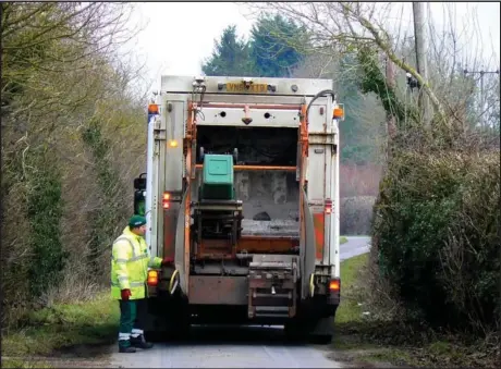  ?? File photo The McLeod River Post ?? For the narrower streets in the UK that are lined with parked cars garbage trucks are rear loading. Generally, there is a driver and two, sometimes three operatives feeding the bins to the back of the truck where they are lifted mechanical­ly and emptied, the bins are then returned to their original locations. Rarely does a householde­r get missed because of the human element. It’s fast and efficient.