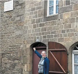  ?? | PHOTO : OUEST-FRANCE ?? Mona Bras, devant l’ancienne auberge de la Veuve-Le Falc’her, au 14, rue des Salles. Sur le mur mitoyen est apposée la plaque commémoran­t la création de la Gorsedd bretonne.