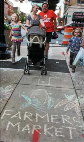  ?? MICHILEA PATTERSON — DIGITAL FIRST MEDIA ?? A sidewalk chalk design points people to the outdoor farmers market in downtown Pottstown. As part of the market’s “Almost Friday” event, there was a sidewalk chalk festival at Smith Family Plaza on Thursday.