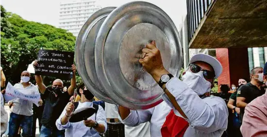  ?? Zanone Fraissat - 27.jan.21/Folhapress ?? Donos de bares e restaurant­es e trabalhado­res do setor protestam contra o fechamento de serviços não essenciais em SP