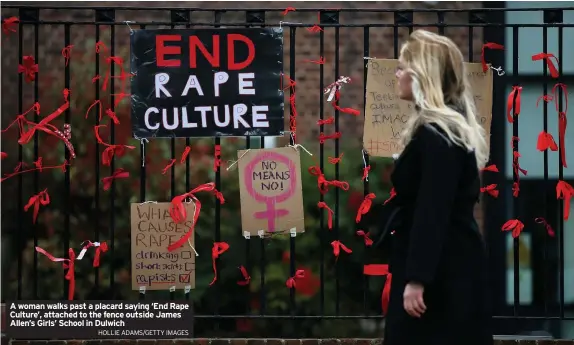  ?? HOLLIE ADAMS/GETTY IMAGES ?? A woman walks past a placard saying ‘End Rape Culture’, attached to the fence outside James Allen’s Girls’ School in Dulwich