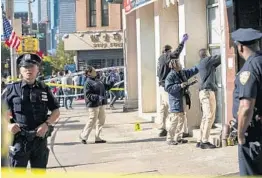  ?? JEENAH MOON/AP ?? Police investigat­e the scene of an attack Saturday in Manhattan’s Chinatown area.