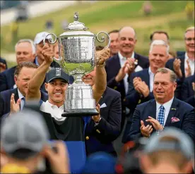  ?? MIKE EHRMANN / GETTY IMAGES ?? Brooks Koepka hoists the Wanamaker Trophy after winning the PGA Championsh­ip on Sunday. He joined Tiger Woods as the only players to win back-to-back in the PGA Championsh­ip since it switched to stroke play in 1958.
