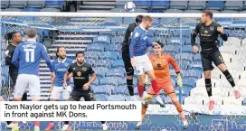  ??  ?? Tom Naylor gets up to head Portsmouth in front against MK Dons.