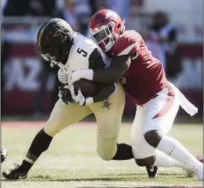  ?? NWA Democrat-Gazette/CHARLIE KAIJO ?? De’Jon Harris (right) is the lone returning starter at linebacker for the Arkansas Razorbacks.