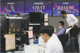  ?? Ahn Young-joon / Associated Press ?? Currency traders watch monitors at the foreign exchange dealing room of the KEB Hana Bank headquarte­rs in Seoul. Asian stocks also did well Thursday.
