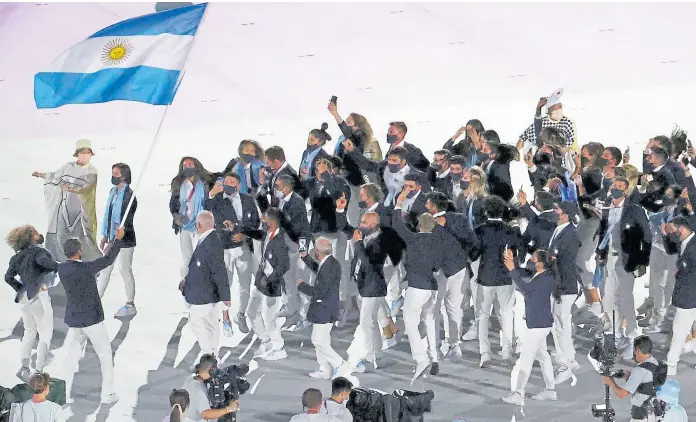  ??  ?? El destile de los argentinos en la apertura, con mucha alegría, saltos y cantos: “Olé olé olé, cada día te quiero más” se hizo sentir; Naomí Osaka encendió el pebetero